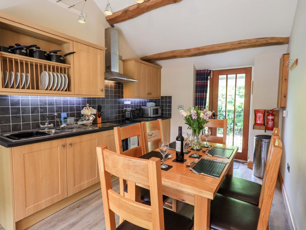 A kitchen with a dining table and chairs at Abbots Reading Mews 1 in Grizedale
