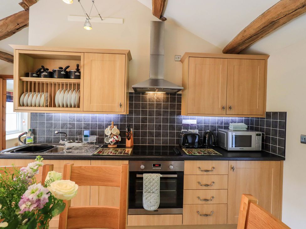 A kitchen with cabinets, sink, stove, microwave at Abbots Reading Mews 1 in Grizedale