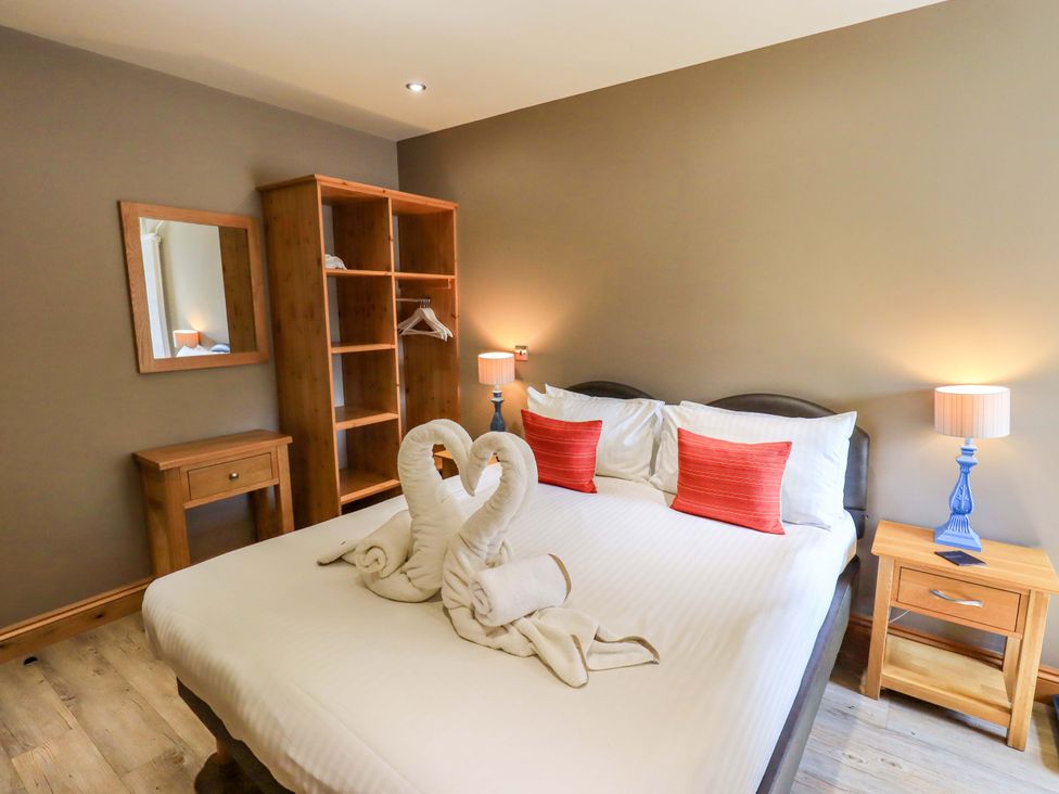 A bedroom with a bed and wooden furniture at Abbots Reading Mews 1 in Grizedale