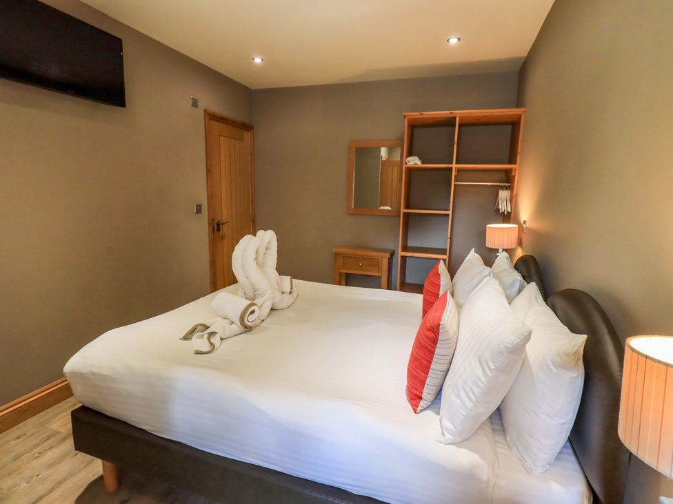 A bedroom with a bed and towels arranged at Abbots Reading Mews 1 in Grizedale