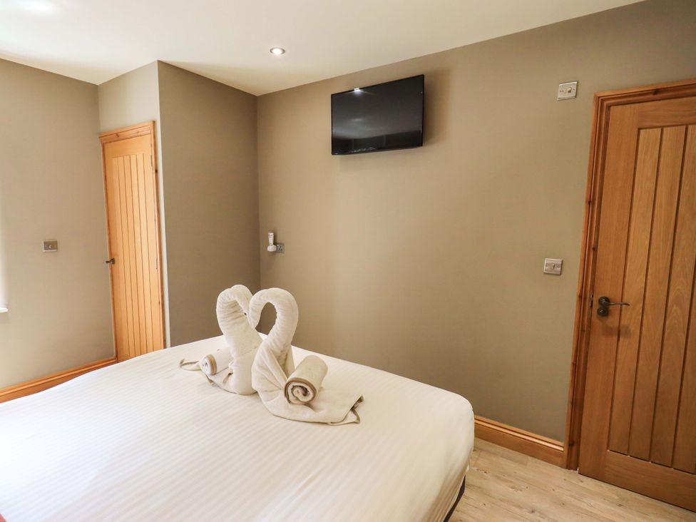 A bedroom with a bed and television at Abbots Reading Mews 1, Grizedale