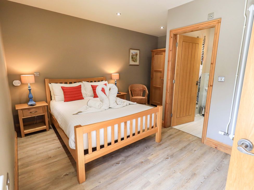 A bedroom with a bed and bedside tables at Abbots Reading Mews 1 in Grizedale