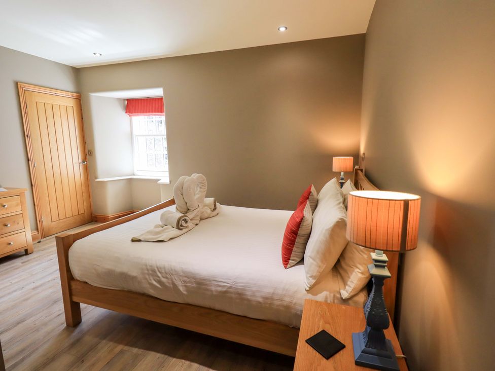 A bedroom with a bed and nightstand at Abbots Reading Mews 1 in Grizedale