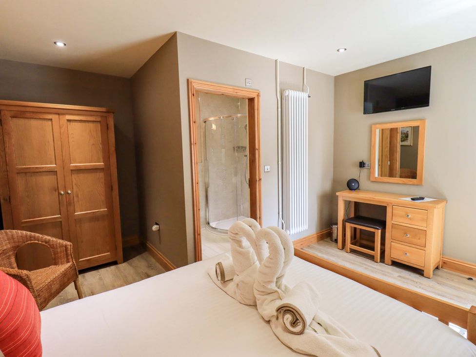 A bedroom with a bed, wardrobe and shower at Abbots Reading Mews 1 in Grizedale