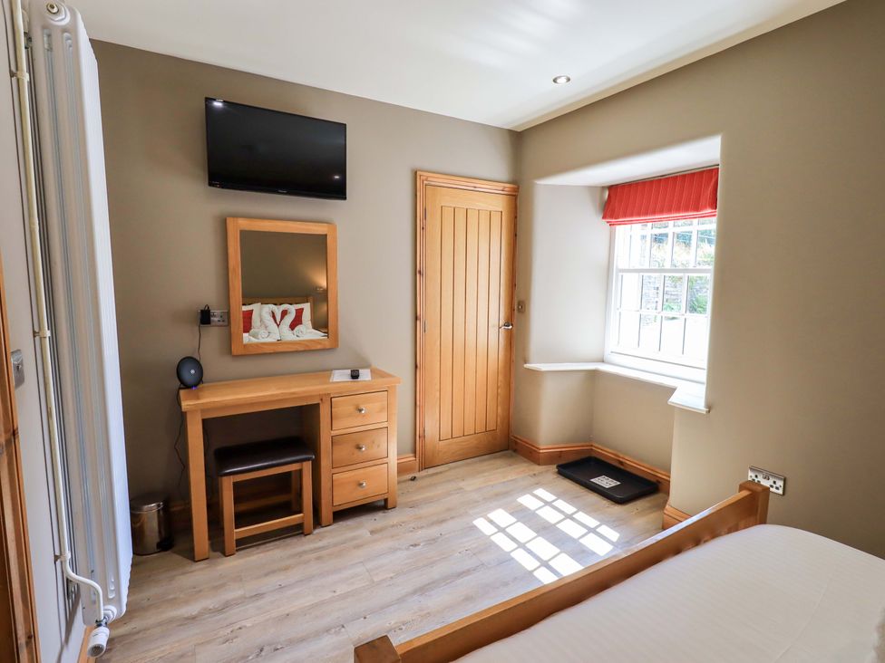 A bedroom with a bed and desk at Abbots Reading Mews 1 in Grizedale
