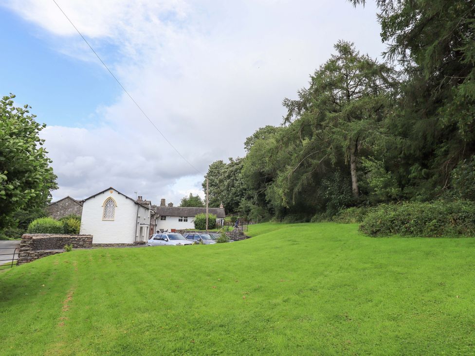 A garden area with a building and cars at Abbots Reading Mews 1 in Grizedale