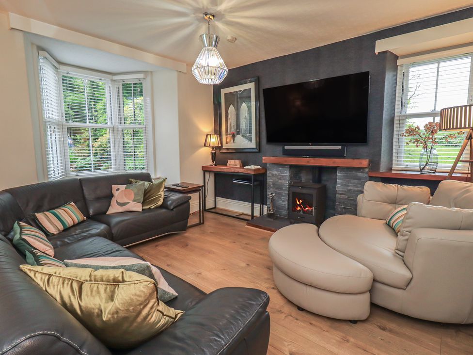 A living room with a sofa and television at Newby Bridge House in Newby Bridge