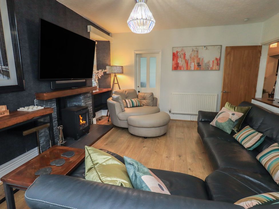 A living room with a television and sofa at Newby Bridge House in Newby Bridge
