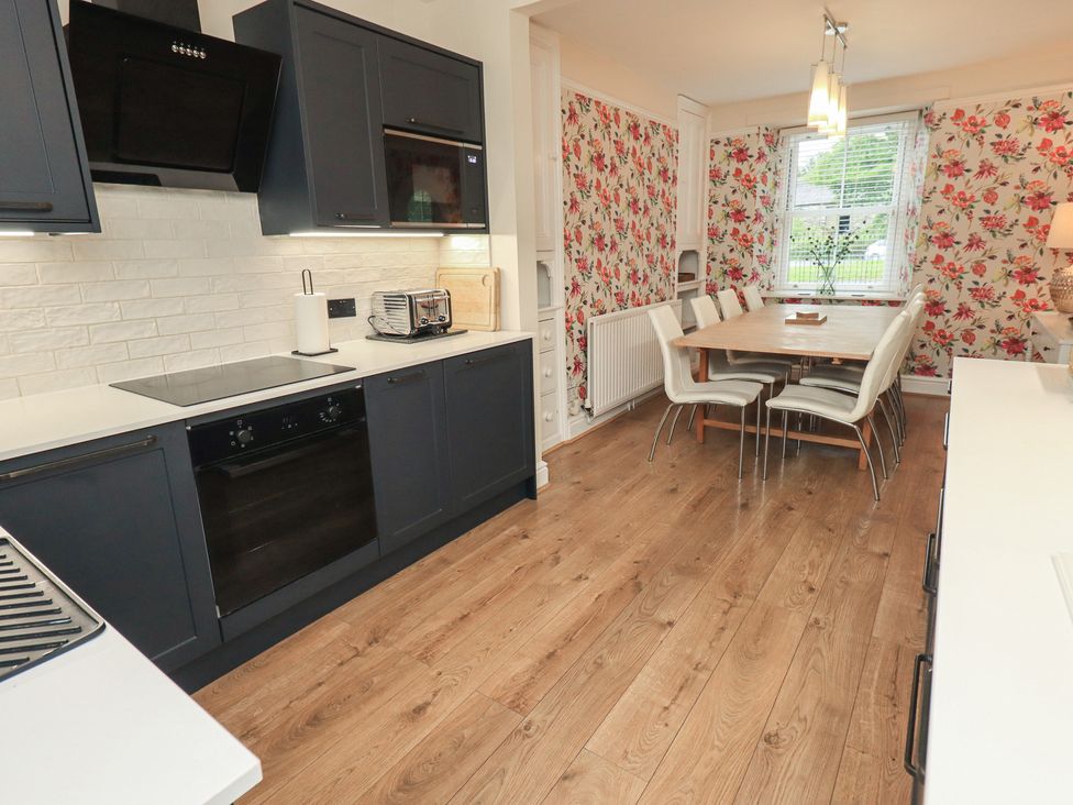 A kitchen with a dining table and chairs at Newby Bridge House in Newby Bridge