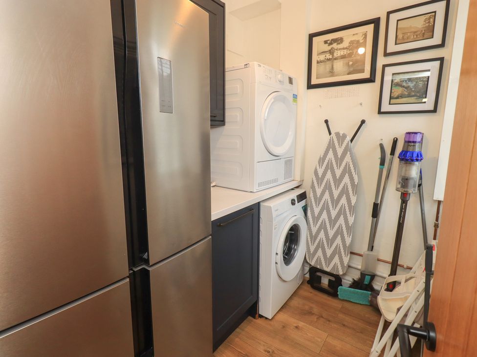 A laundry room with a refrigerator and appliances at Newby Bridge House in Newby Bridge