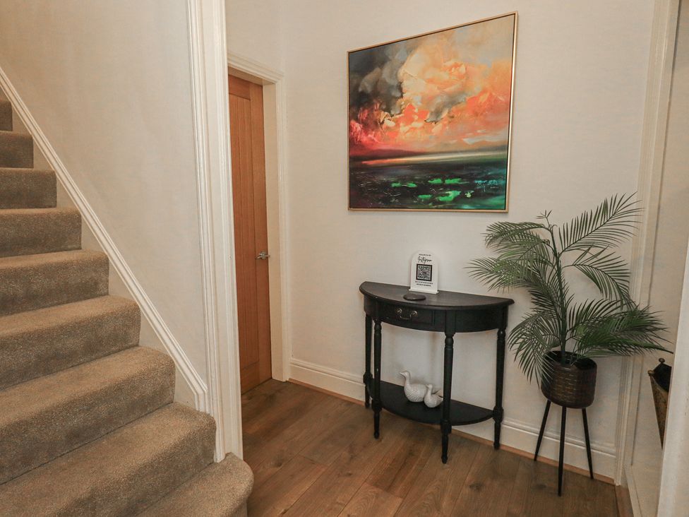 A hallway with stairs and a table at Newby Bridge House in Newby Bridge