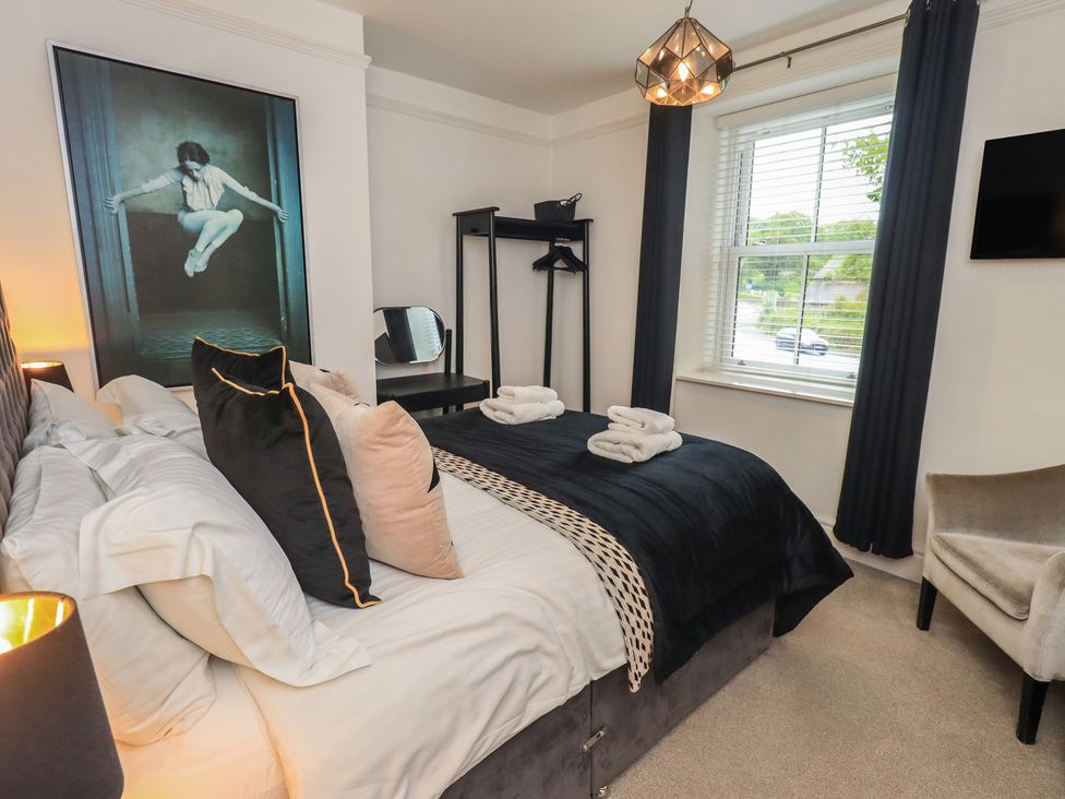 A bedroom with a bed and a wardrobe at Newby Bridge House in Newby Bridge