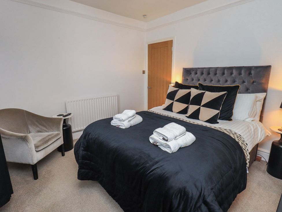 A bedroom with a bed and armchair at Newby Bridge House in Newby Bridge