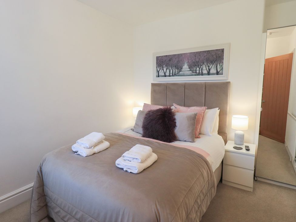 A bedroom with a bed and bedside table at Newby Bridge House in Newby Bridge