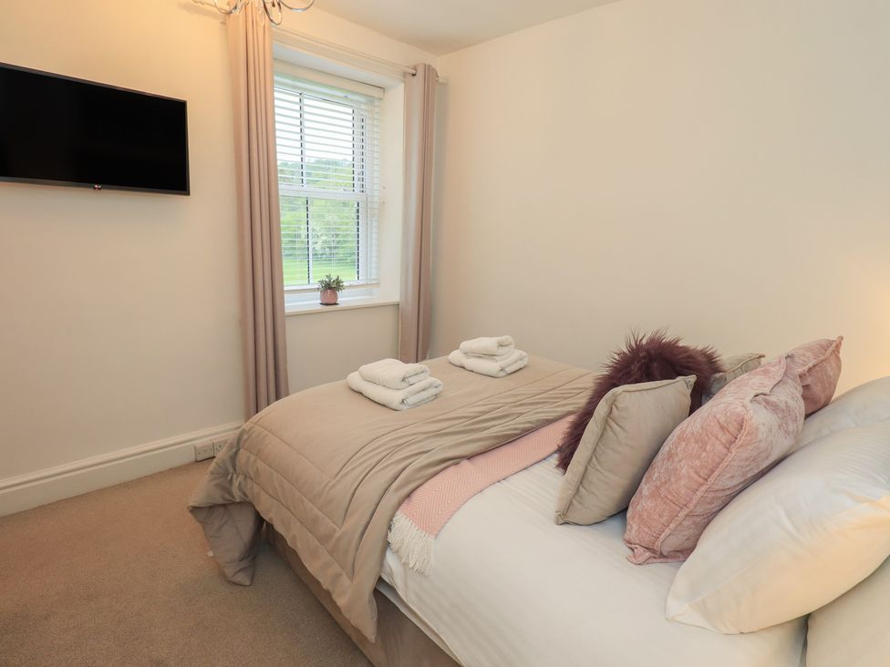 A bedroom with a bed and television at Newby Bridge House in Newby Bridge
