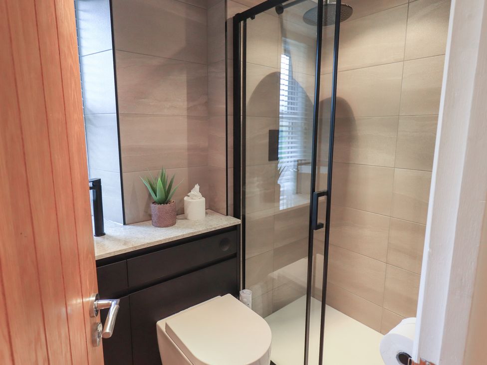 A bathroom with a shower and toilet at Newby Bridge House in Newby Bridge