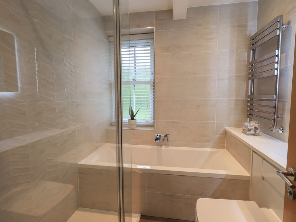 A bathroom with bathtub and sink at Newby Bridge House in Newby Bridge