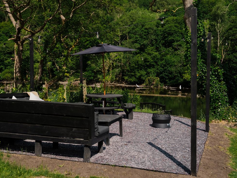 An outdoor seating area with a bench and a table at Newby Bridge House in Newby Bridge