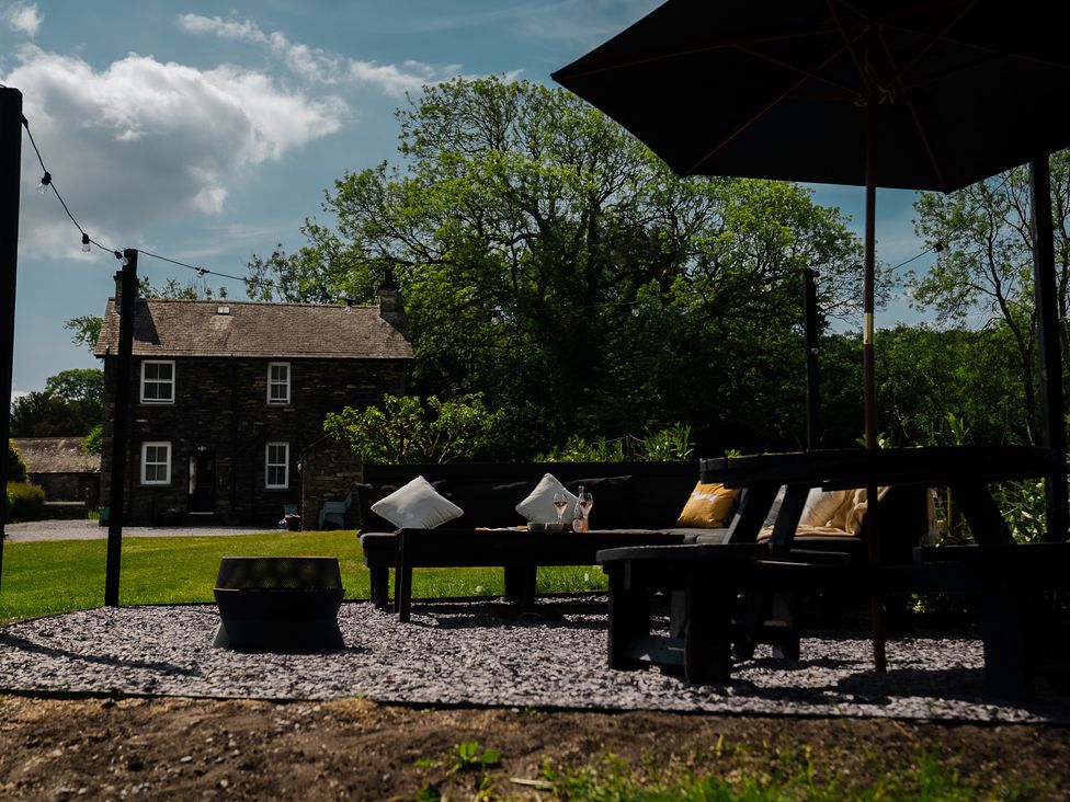 A garden with seating and a house in the background at Newby Bridge House in Newby Bridge