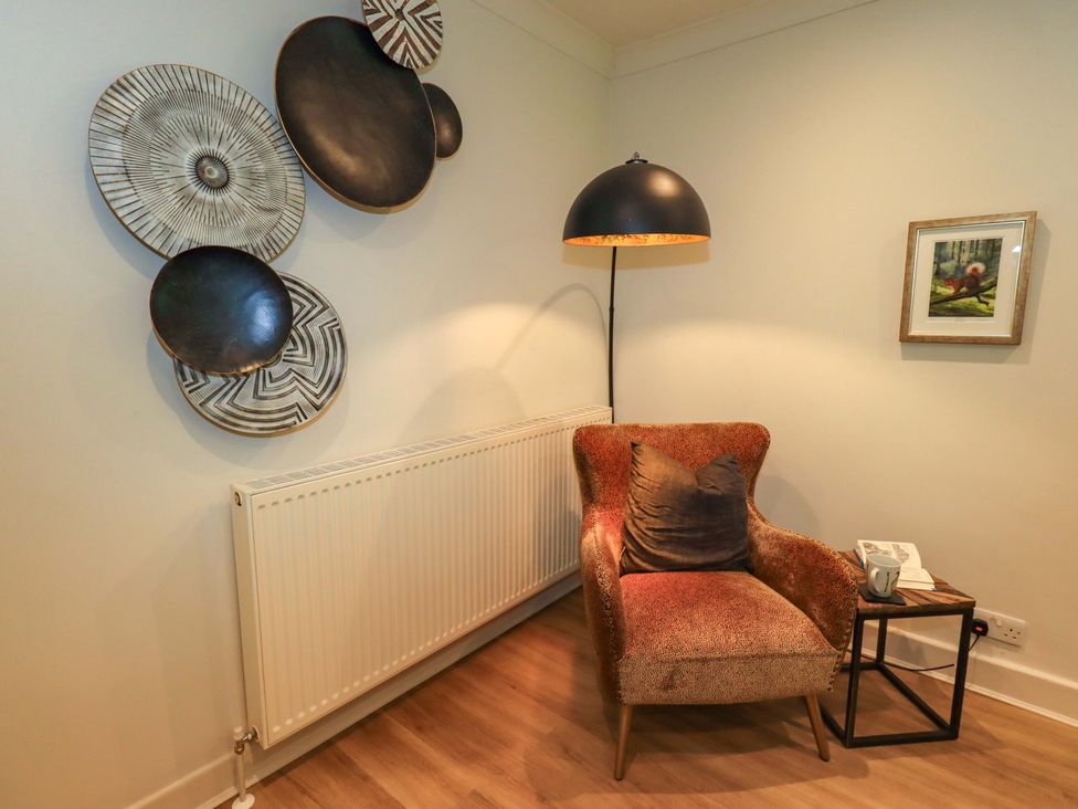 A living room with a chair and side table at Underheron in Grasmere