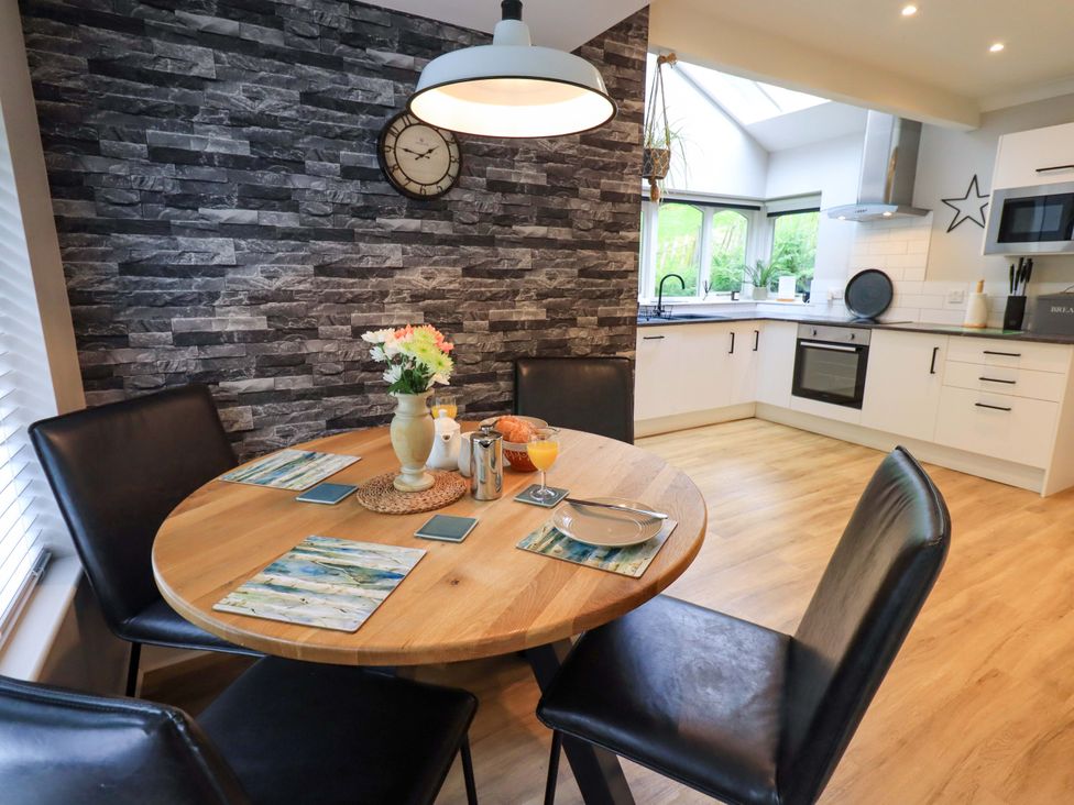 A dining room with a round table and chairs at Underheron in Grasmere