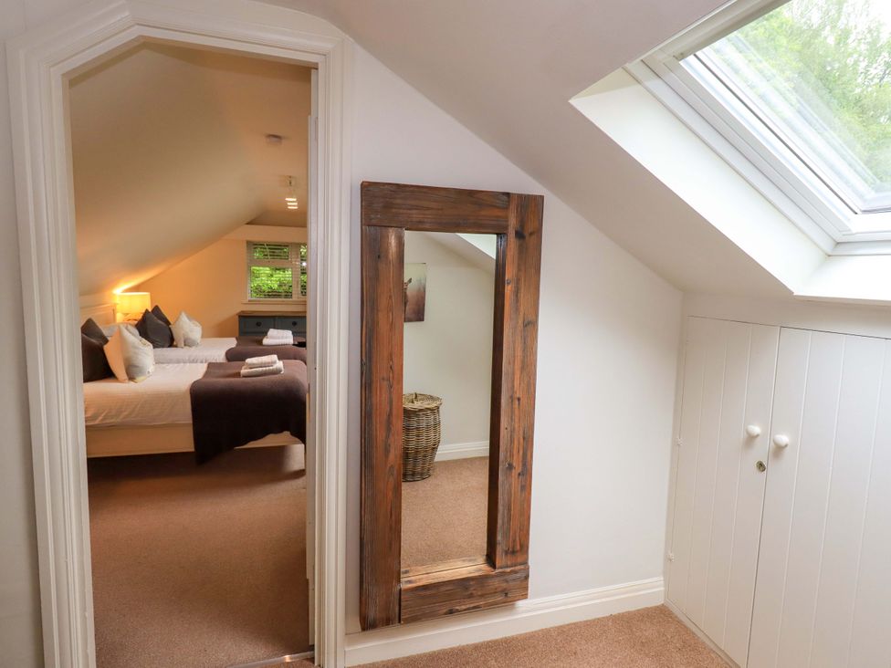 A bedroom with a mirror and a bed with pillows at Underheron in Grasmere