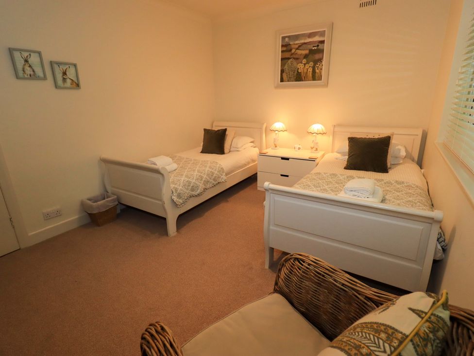 A bedroom with two single beds and bedside lamps at Underheron in Grasmere