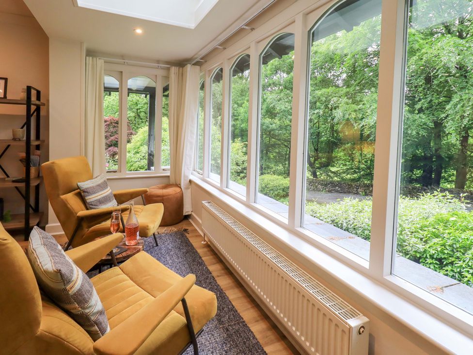 A conservatory with chairs and a table at Underheron in Grasmere