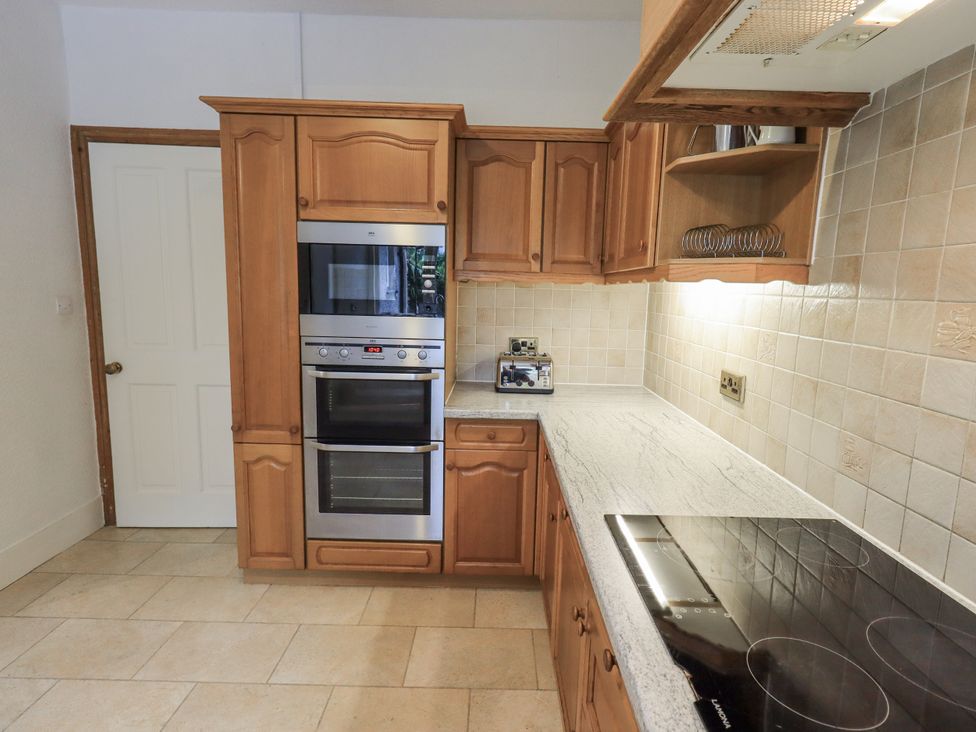 A kitchen with appliances and cabinets at Miyanli in Bowness
