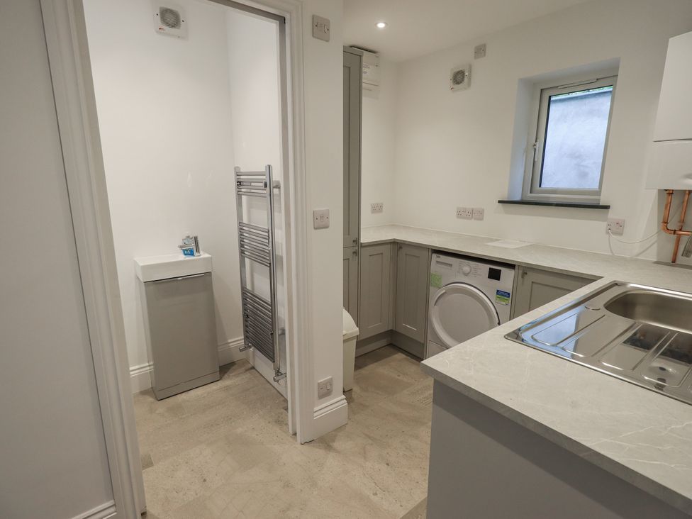 A laundry room with a washing machine and sink at Miyanli in Bowness