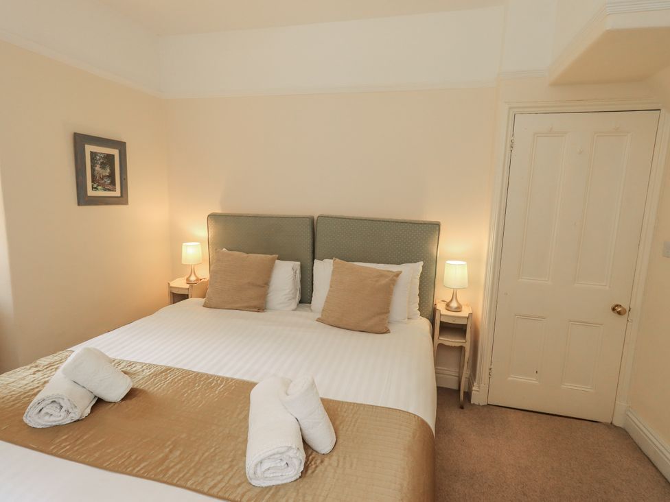 A bedroom with a double bed and lamps at Miyanli in Bowness
