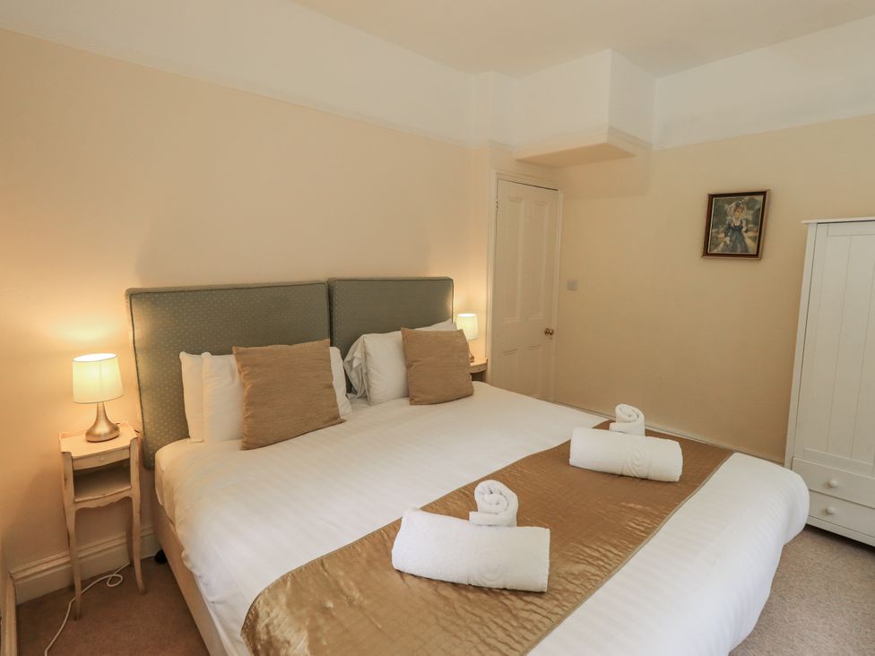 A bedroom with a large bed and bedside table at Miyanli in Bowness