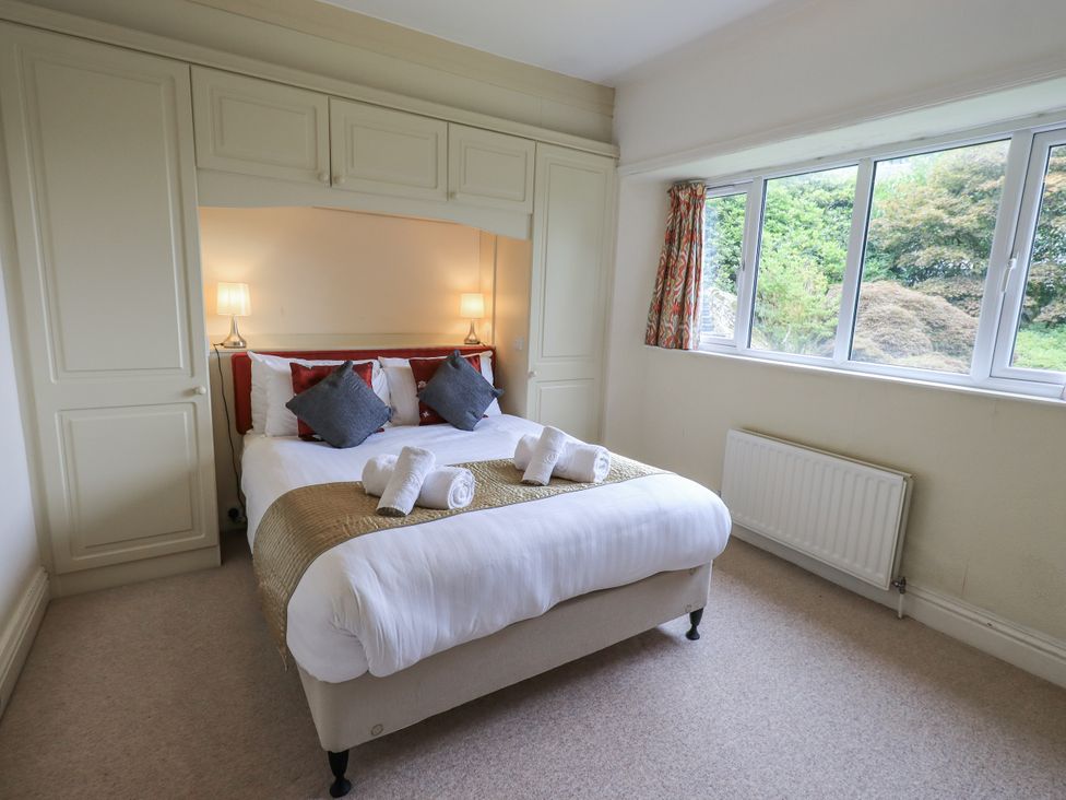 A bedroom with a bed and windows at Miyanli in Bowness