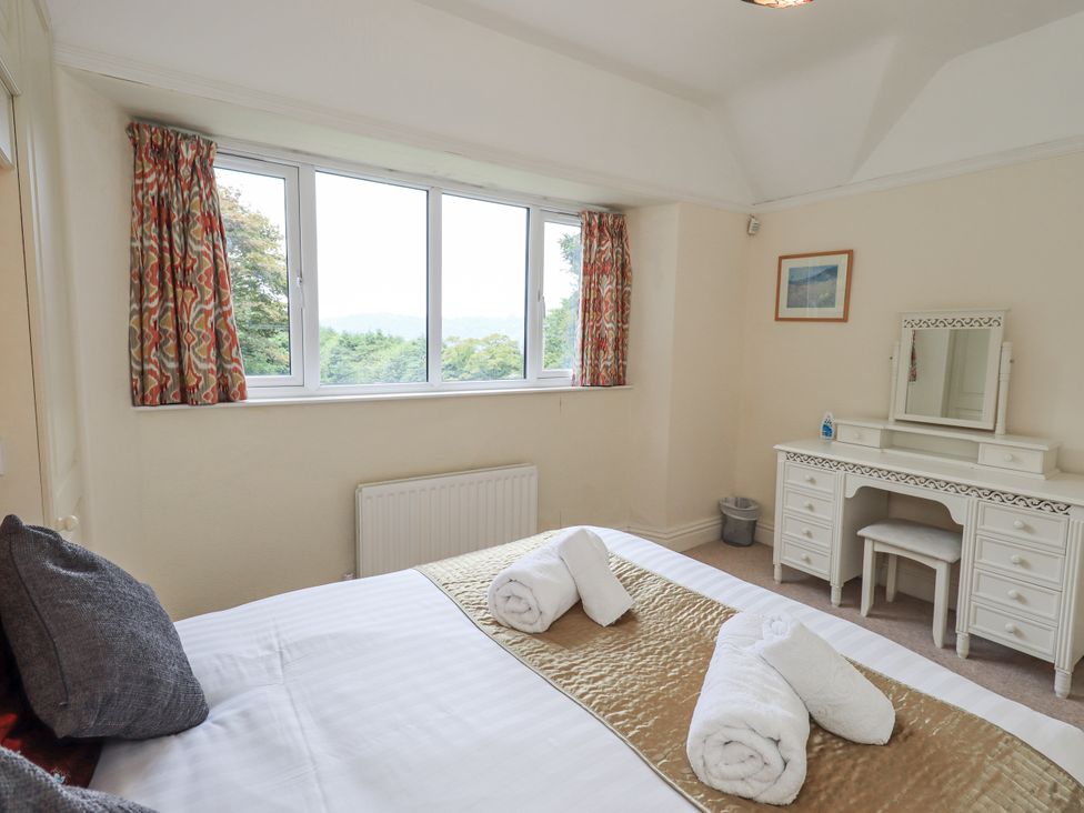 A bedroom with a bed and a vanity table at Miyanli in Bowness