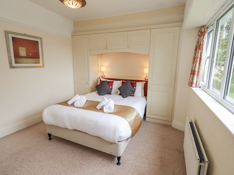 A bedroom with a bed and wardrobe at Miyanli in Bowness