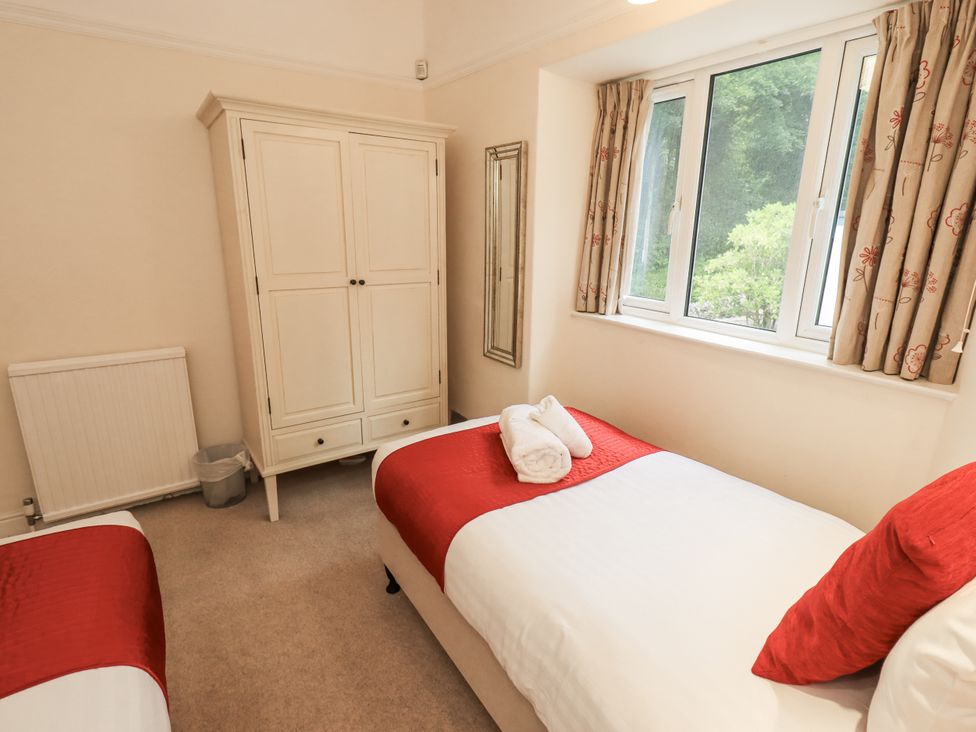 A bedroom with two beds and a wardrobe at Miyanli in Bowness