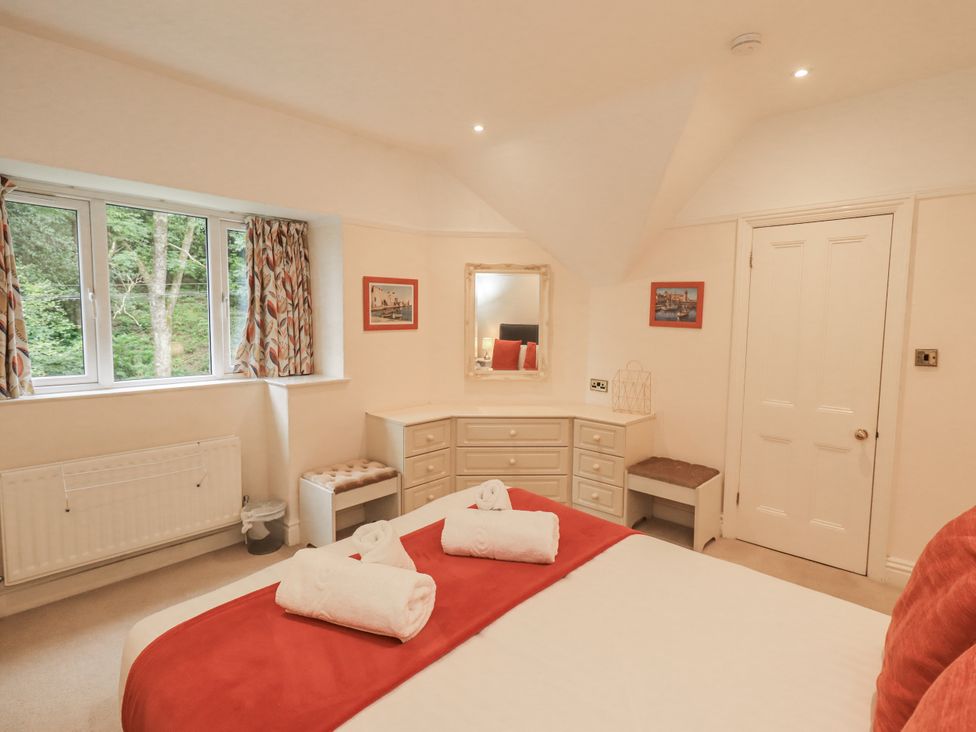 A bedroom with a bed and dresser at Miyanli in Bowness