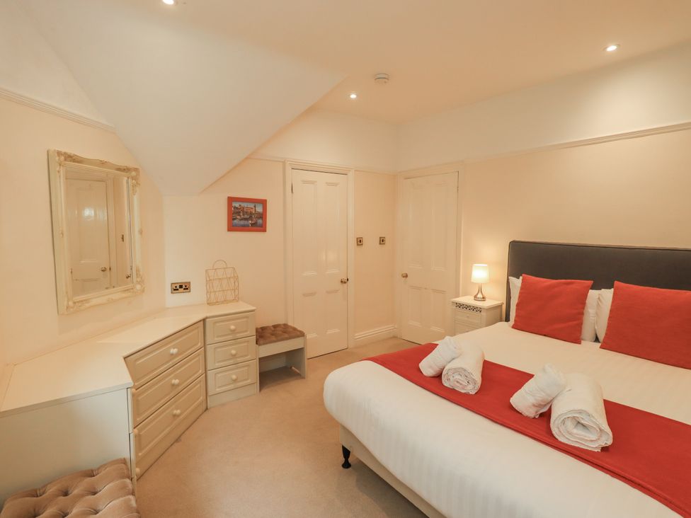 A bedroom with a bed, dresser, and mirror at Miyanli in Bowness