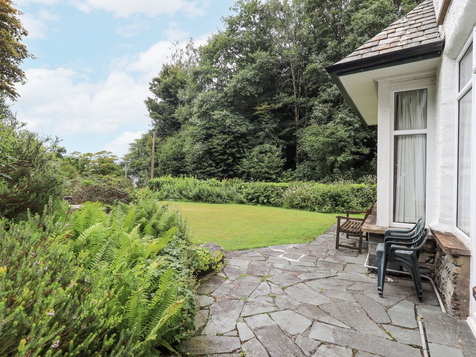 A garden with stone path and chairs at Miyanli in Bowness
