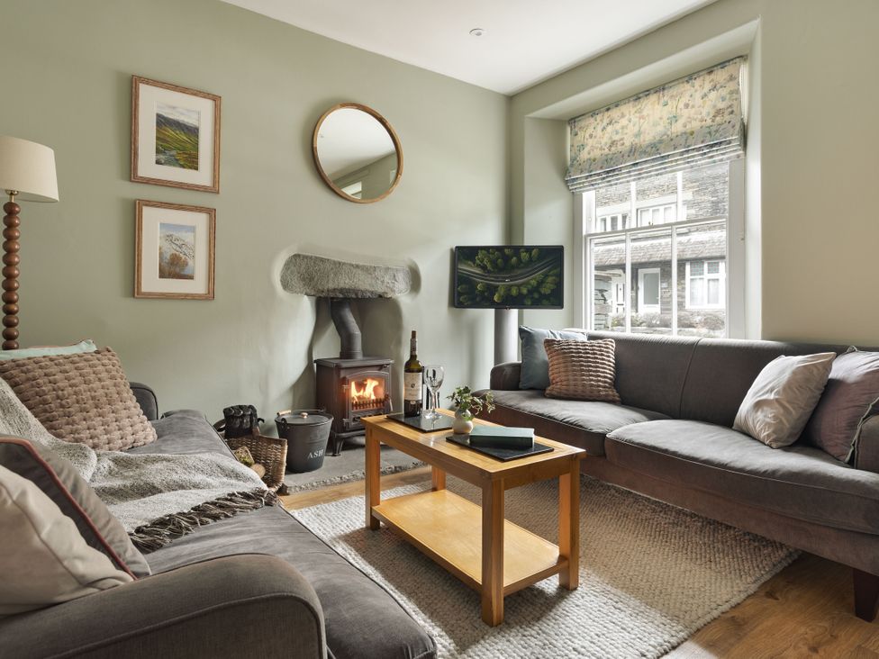 A living room with a fireplace and a coffee table at Herdwick Cottage Ambleside