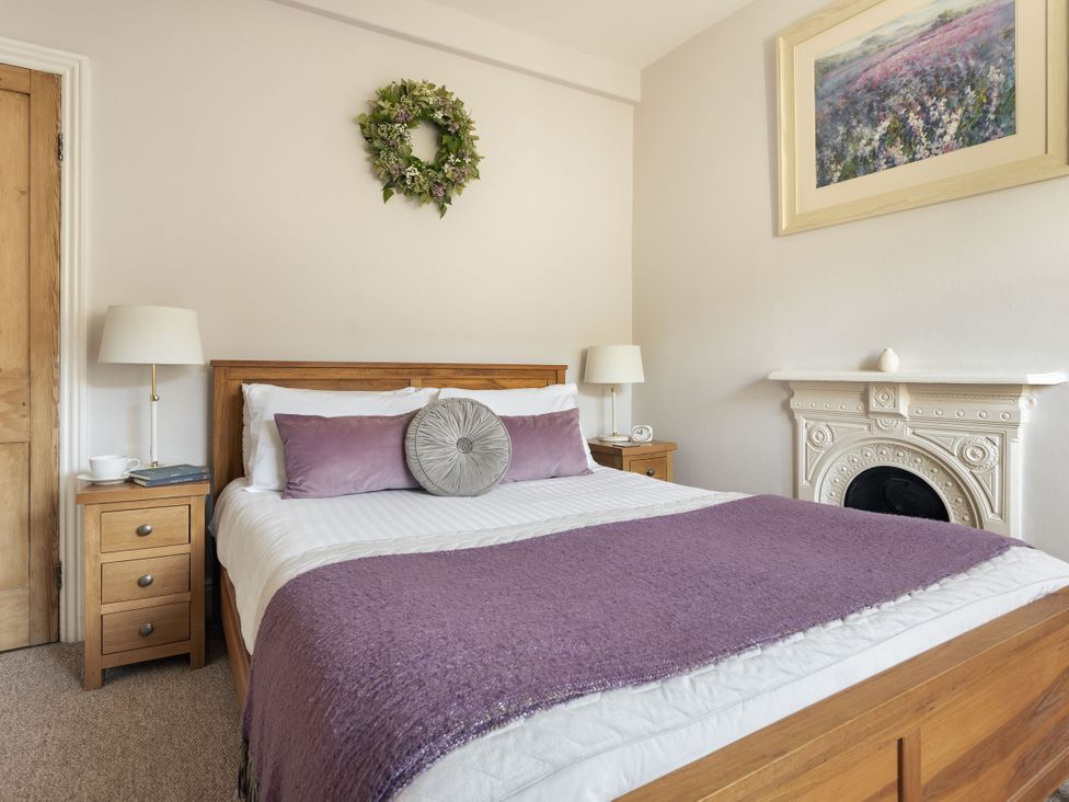 A bedroom with a bed and bedside tables at Herdwick Cottage Ambleside