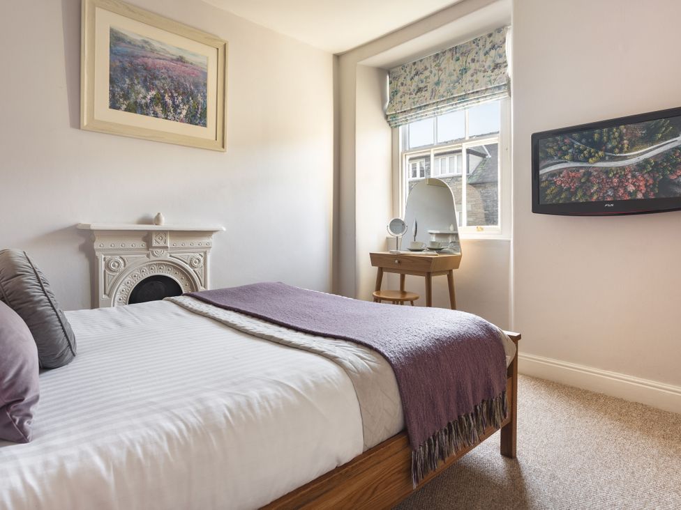 A bedroom with a bed and television at Herdwick Cottage Ambleside