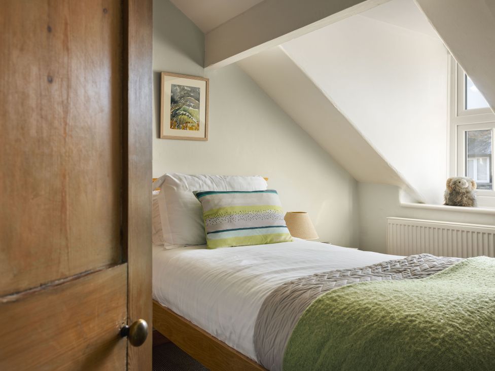 A bedroom with a bed and a window at Herdwick Cottage Ambleside