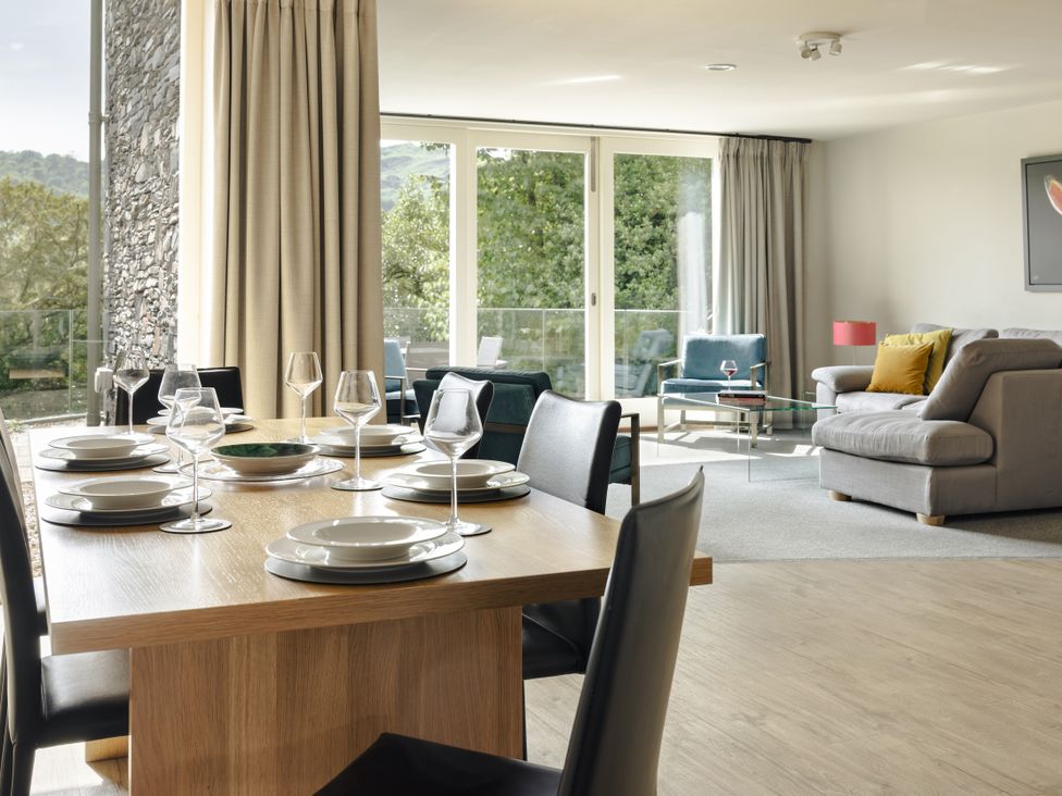A dining area with a table set and a living room at Take Five in Ambleside
