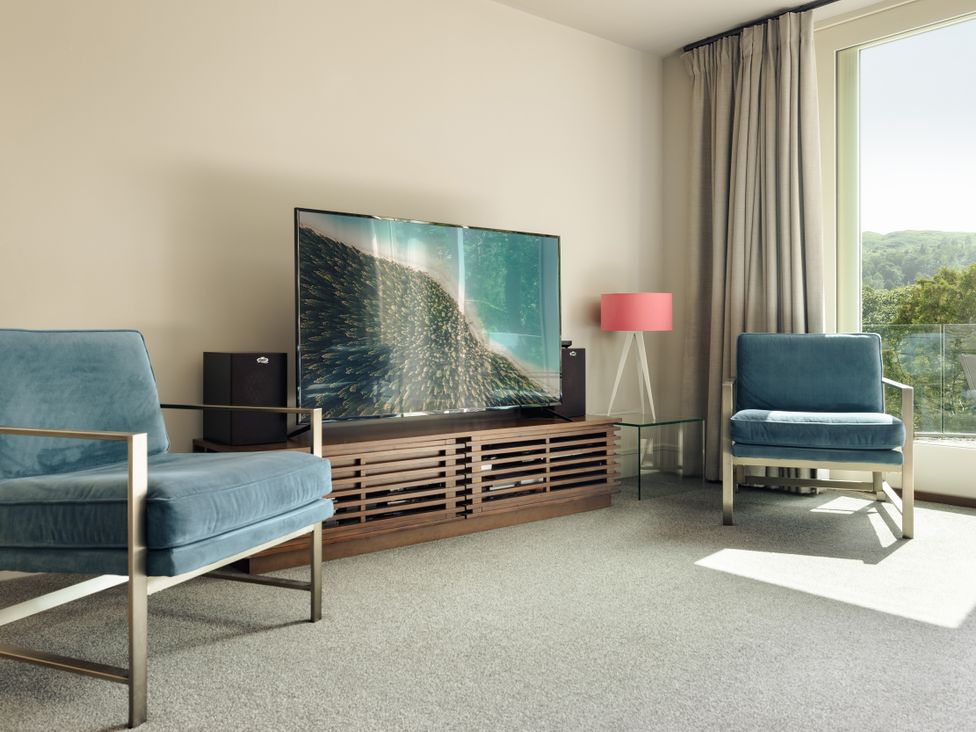 A living room with a television and armchairs at Take Five in Ambleside