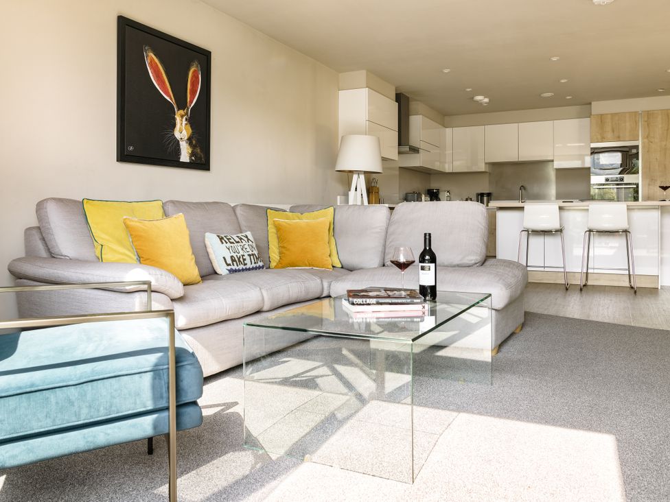 A living room with a sofa and glass coffee table at Take Five in Ambleside