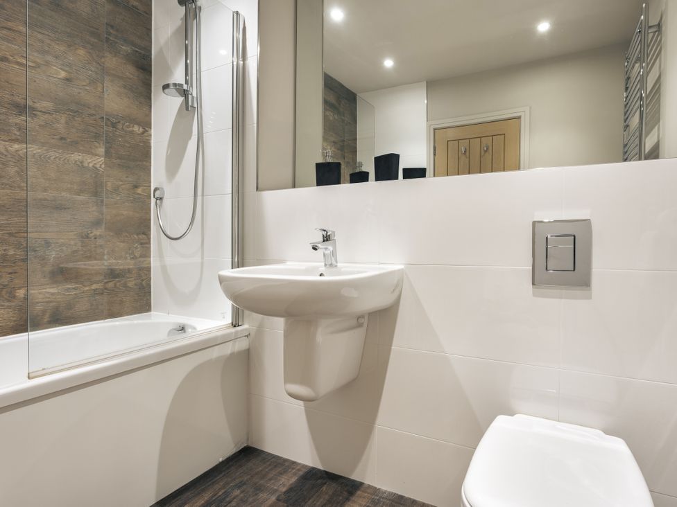 A bathroom with a bathtub, toilet, and washbasin at Take Five in Ambleside