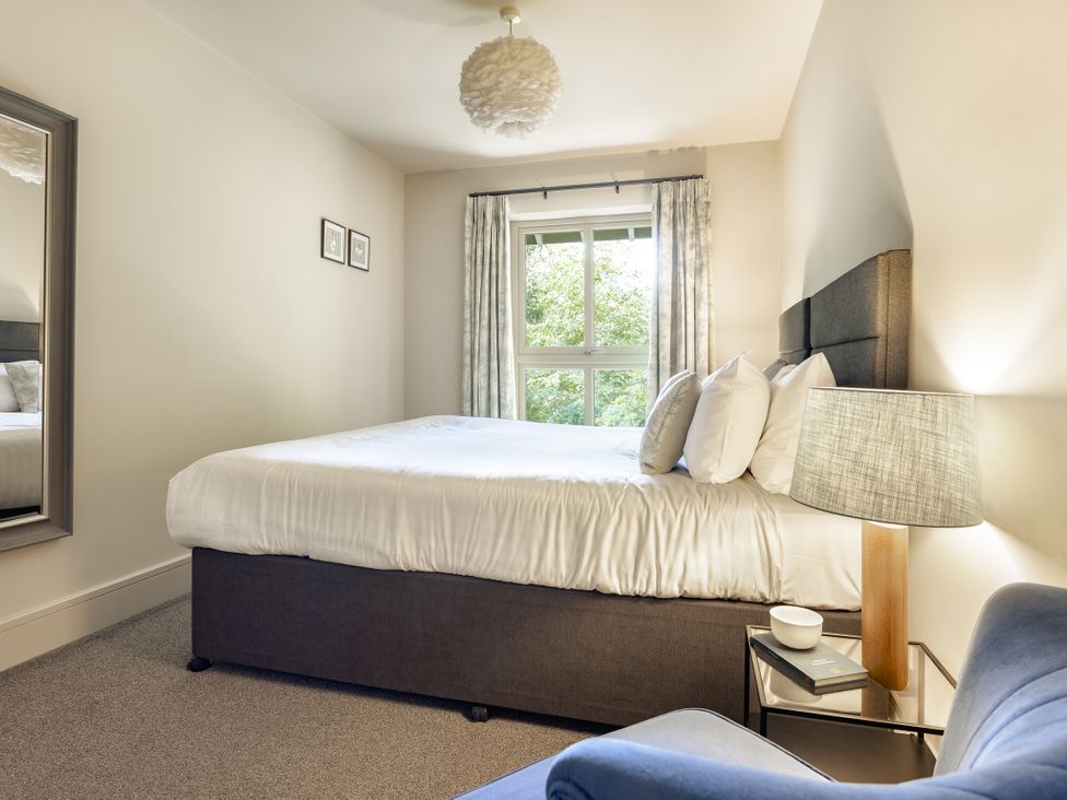 A bedroom with a bed and mirror at Take Five in Ambleside