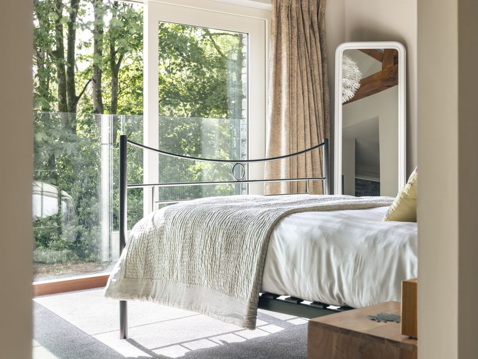 A bedroom with a bed and a mirror at Take Five in Ambleside