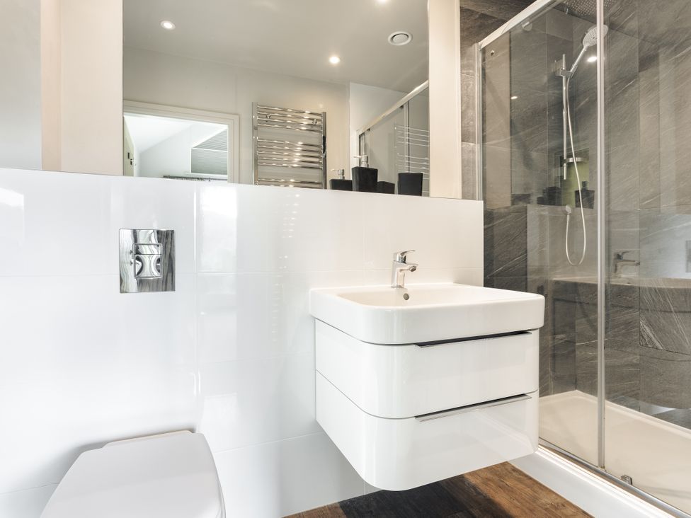 A bathroom with a sink, toilet, shower, and towel radiator at Take Five in Ambleside